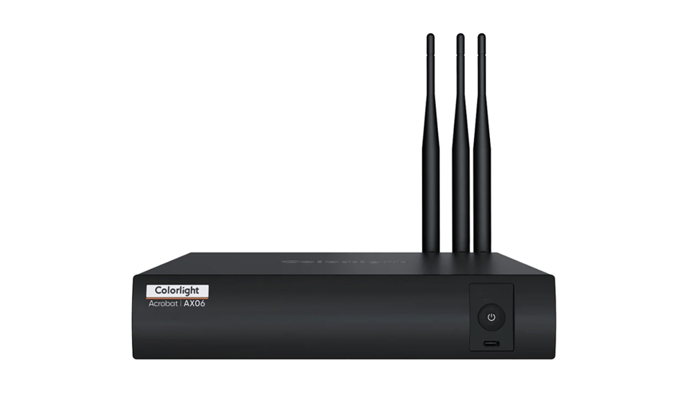Black set-top box with three tall external antennas and a power button on the right; labeled Colorlight Acrobat AX06 (AX06).